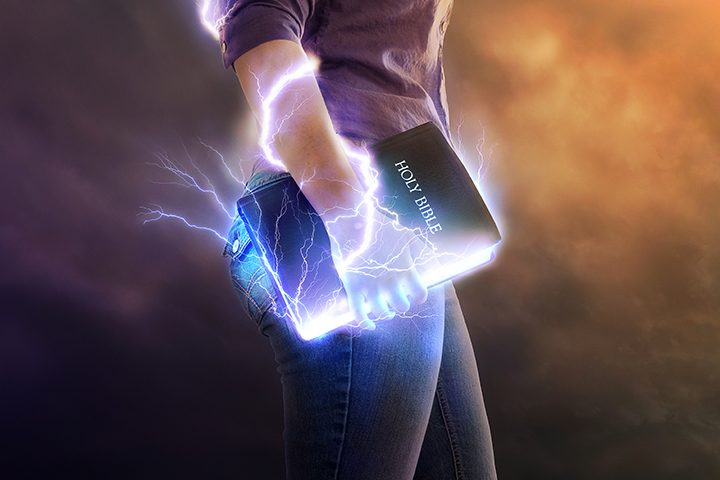 A person holding an open book with lightning coming from it.